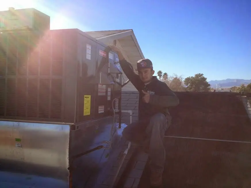 HVAC technician performing Heat Pump Repair on a rooftop unit in Iona
